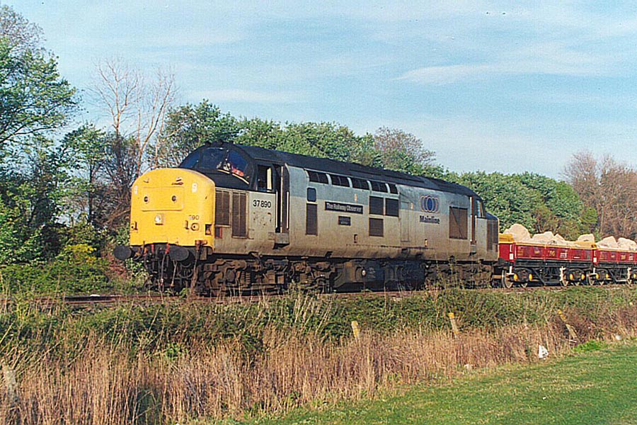 37890 The Railway Observer brings the 13.15 stone train ex-Merehead quarry into Minehead on 30th April 1997.  The large stones are for strengthening the sea walls at Minehead. Geoff Bannister