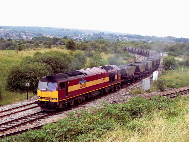 60001 at Hawkeridge Junction, north of Westbury, with 6B63 Westbury cement works to Margam yard empty MGR, 2nd August 2004. Mark Few
By this time coal for power stations was only conveyed in bogie wagons. 4 wheel coal wagons were only used to take coal to cement works including Westbury, as in this photograph, Clitheroe and Penyffordd. Coal for Ketton was conveyed in megaboxes. 60001 conveyed coal at least once to each of these cement works.